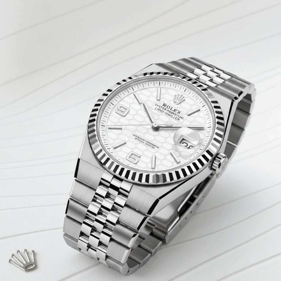 Photographie macro haute résolution d'une montre de luxe en acier avec cadran argenté à motifs géométriques. La montre possède une lunette cannelée, un bracelet Jubilee poli et est présentée sous un éclairage studio professionnel sur un fond blanc épuré.