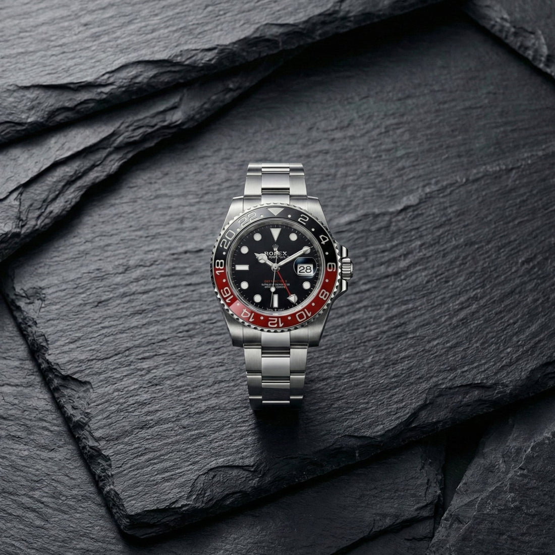 Photographie ultra-détaillée 4K d'une montre de luxe Rolex GMT-Master II avec lunette "Coke" rouge et noire, bracelet Oyster en acier, posée sur une surface en ardoise sombre texturée. Rendu professionnel pour blog horloger.