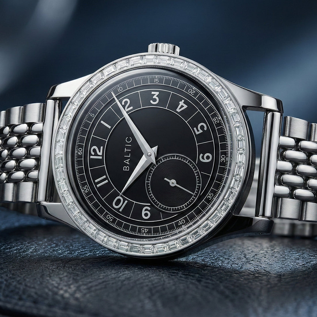 Montre Baltic avec cadran noir, lunette sertie de diamants taille baguette et bracelet en acier inoxydable perles de riz. Un garde-temps vintage élégant et détaillé.